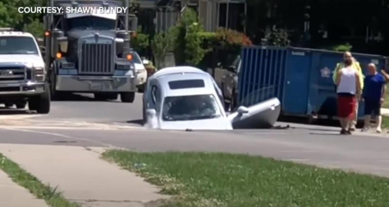  - Une canalisation éclate, cette voiture se retrouve happée dans un trou au milieu de la route