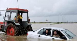 Sur une route inondée par la tempête Nils, un tracteur vient en aide à une voiture totalement bloquée