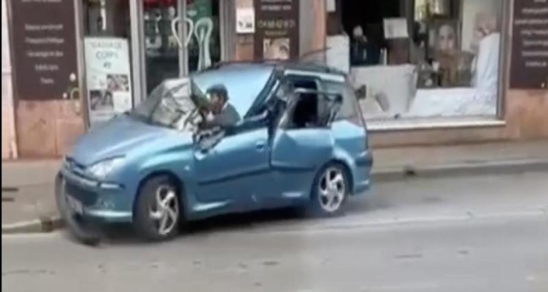  - Un conducteur reprend la route au volant d’une épave, la tête hors du véhicule