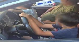 Son fils de 9 ans conduit l'Audi Q7 sur le Prado pendant qu'il tient le volant d'une main avec un autre gamin sur les genoux