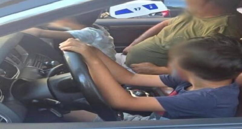 Son fils de 9 ans conduit l'Audi Q7 sur le Prado pendant qu'il tient le volant d'une main avec un autre gamin sur les genoux