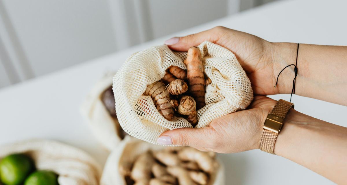 Une femme tient dans ses mains un petit sac avec du curcuma.