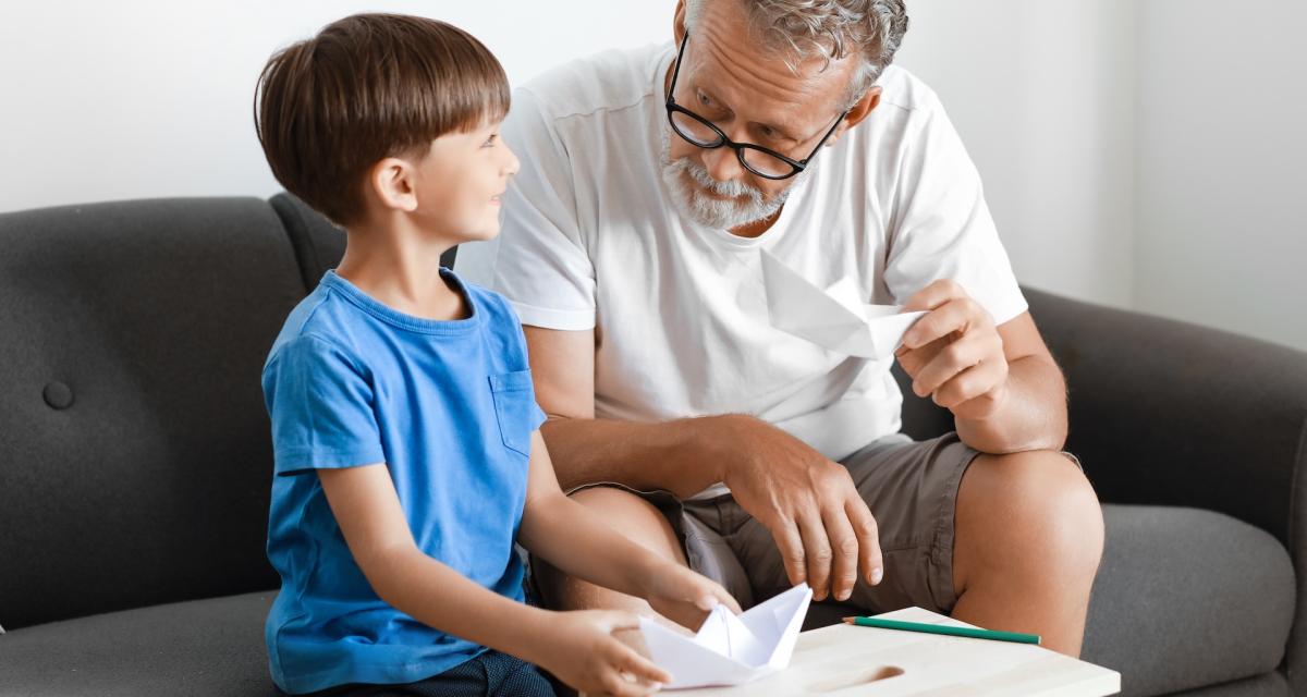 Un grand-père et son petit-fils font de l'origami.