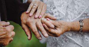 60 ans de mariage : offrir le cadeau idéal pour les noces de diamant - Un homme âgé passe une bague au doigt de sa femme pour leurs 60 ans de mariage.