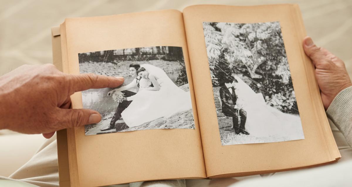 Un couple de grands-parents regardent un album photo avec leurs photos de mariage.