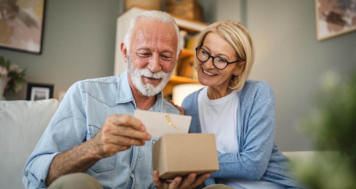 Un couple lit la carte de voeux qui accompagne un cadeau