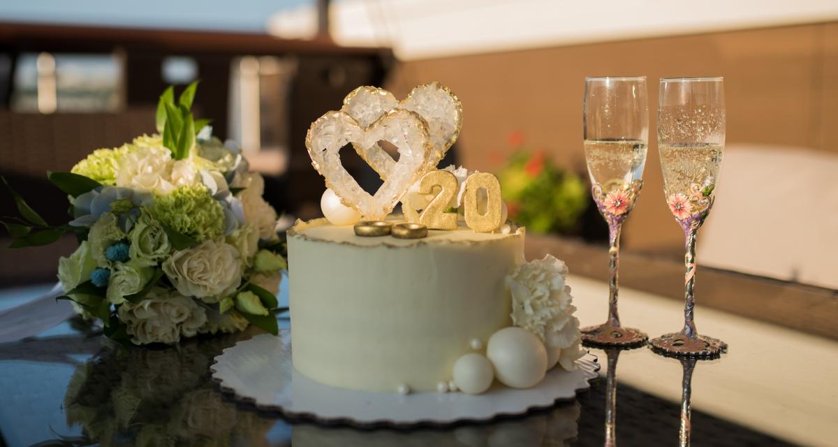 Gâteau de mariage avec le numéro 20, bouquet de fleurs et flûtes de champagne pour célébrer 20 ans de mariage.