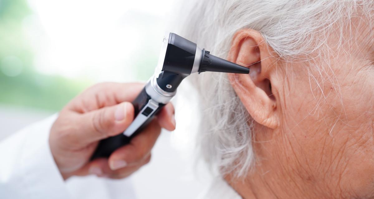 Un ORL examine l'oreille d'un patient âgé.