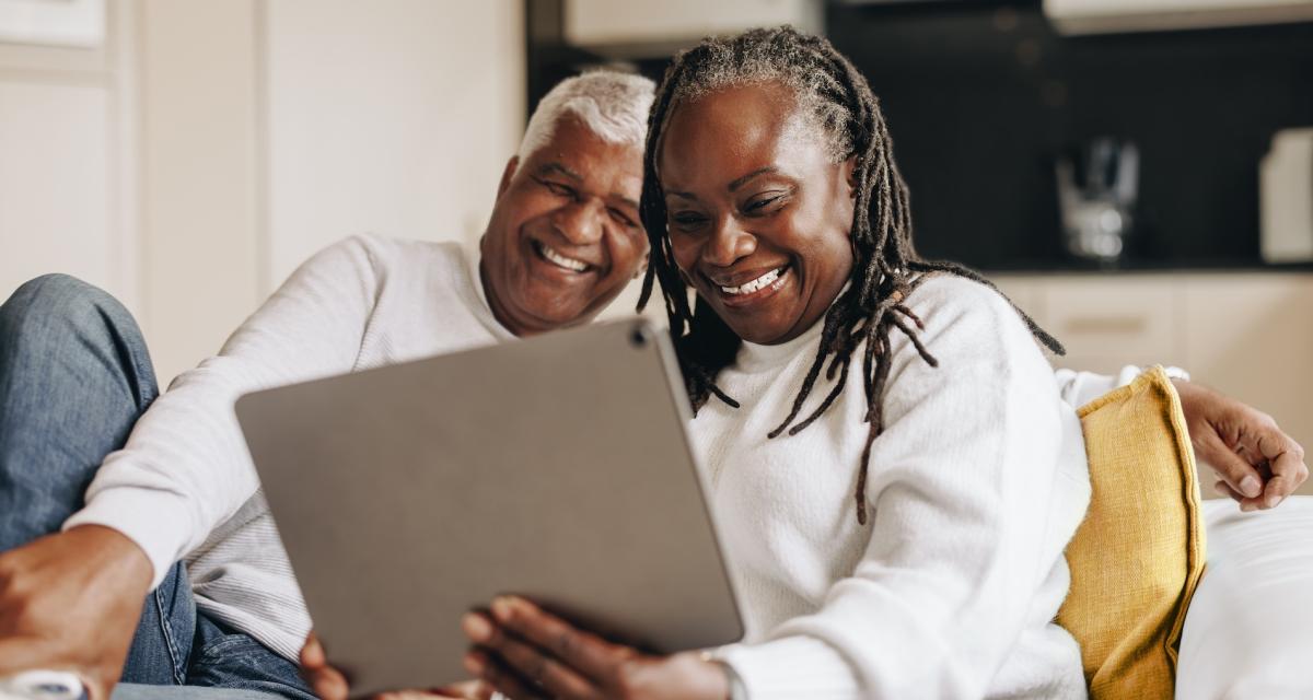 Un couple de senior en visio avec leurs proches sur leur tablette.