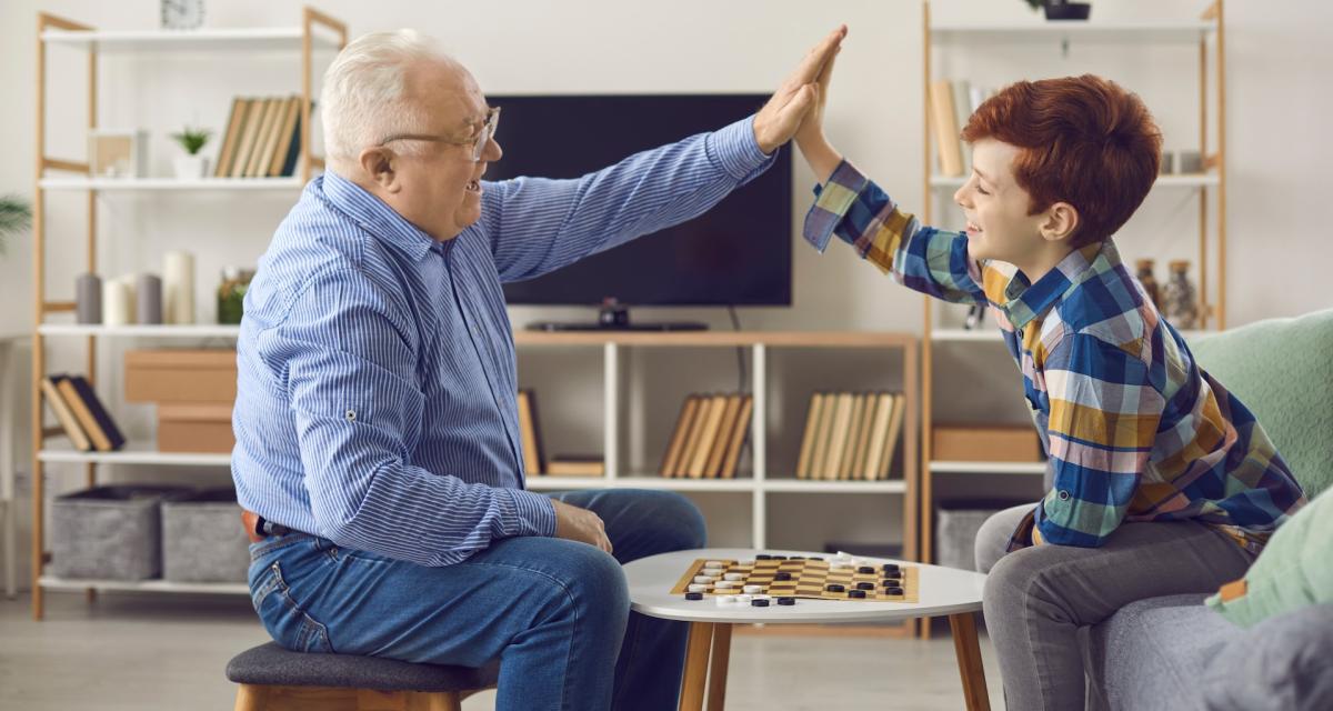 Un grand-père joue aux dames avec son petit-fils.