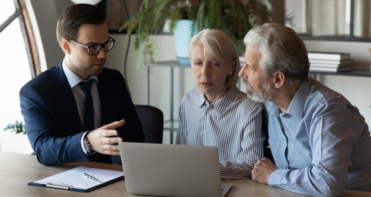 Un couple de seniors en plein rendez-vous avec un conseiller au sujet de la fiscalité de l'assurance vie en succession.