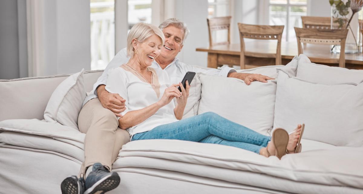 Un couple de seniors rigolent devant un GIF.