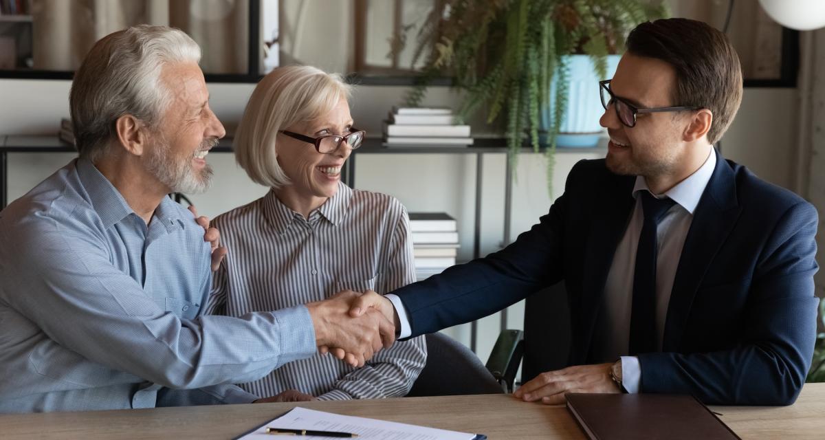 Un couple senior en pleine négociation avec un conseiller financier spécialisé.