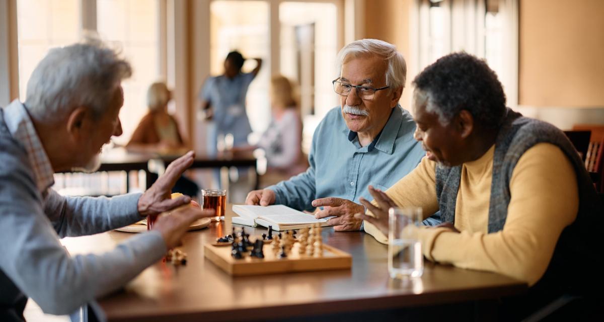 Des seniors en pleine partie d'échecs dans leur résidence.