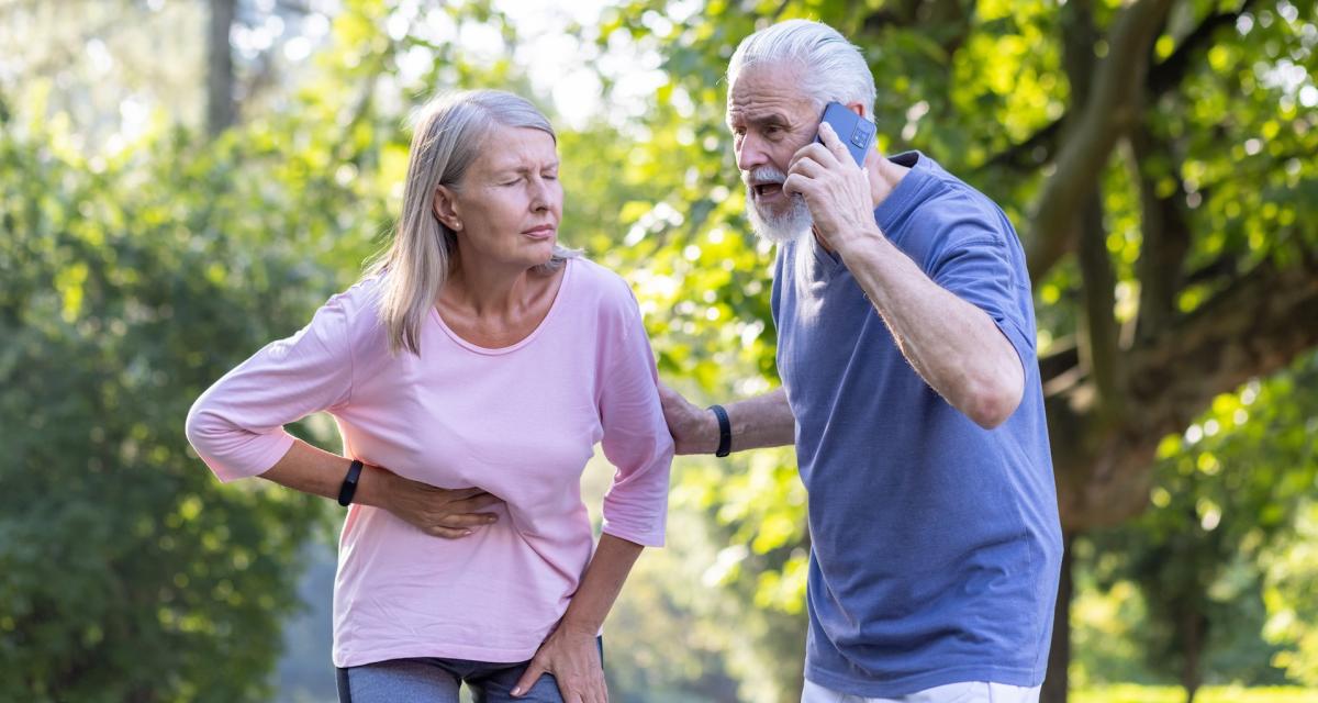 Une dame semble faire un malaise cardiaque et un homme prévient les secours.