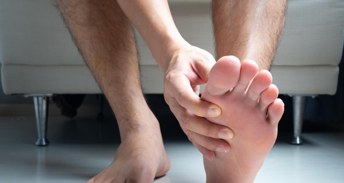 Un homme souffre d'une douleur au gros orteil, un des symptômes d'une crise de goutte.