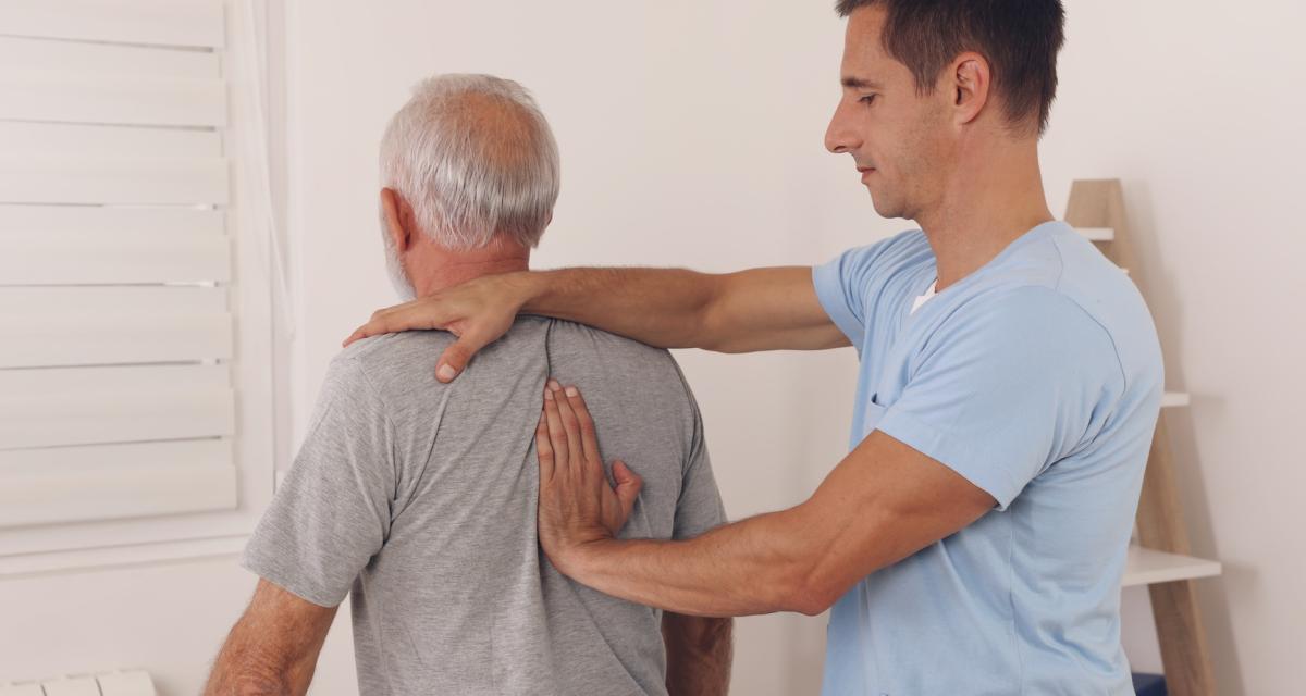 Un ostéopathe en plein séance avec un patient senior.