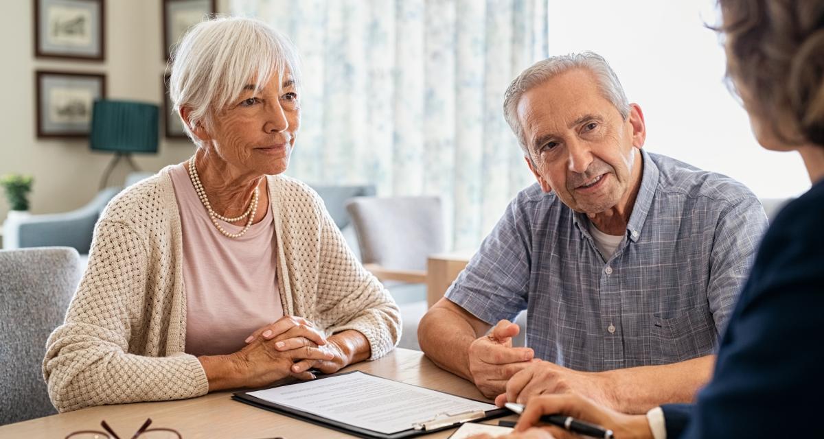 Un couple senior rencontre une conseillère médicale pour choisir la meilleure mutuelle santé.