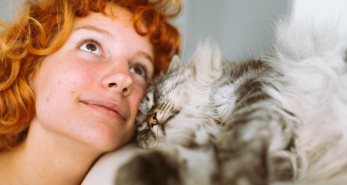 Une jeune fille fait un câlin à son chat.