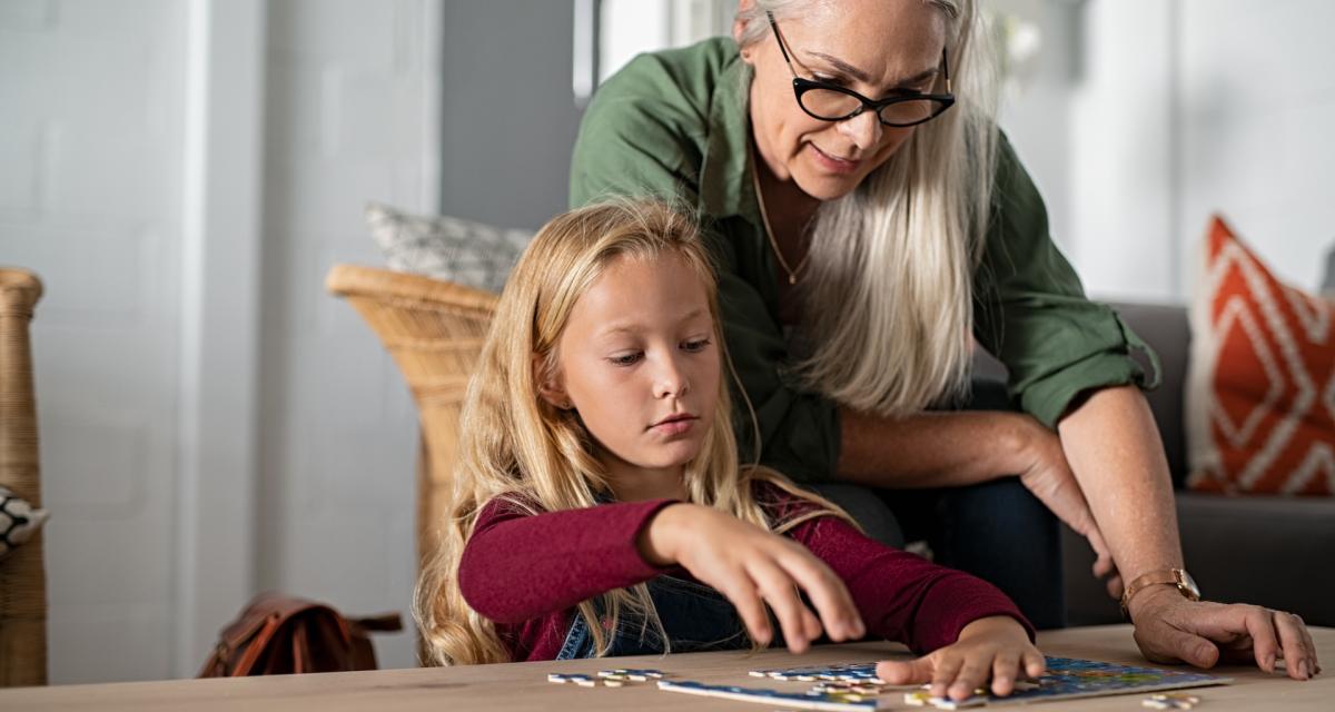 Une grand-mère fait un puzzle avec sa petite-fille.