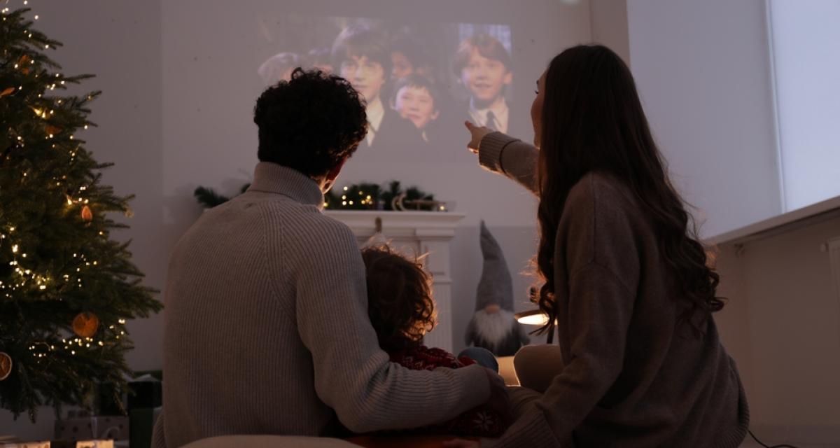 Une famille en train de regarder Harry Potter sur un vidéo projecteur à la maison.