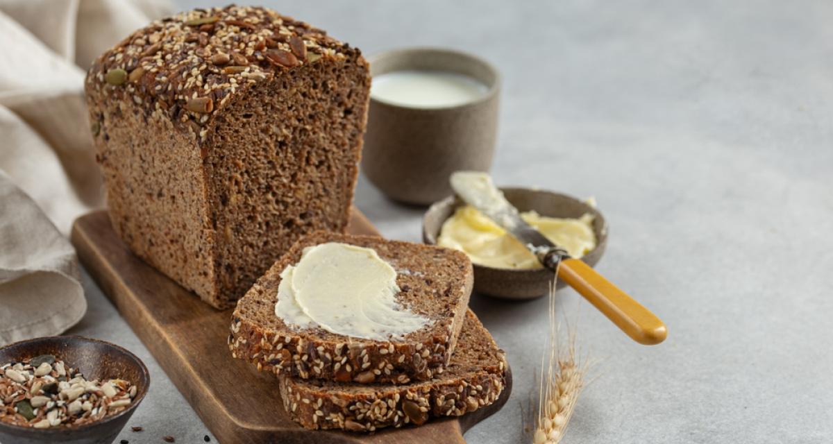 Tranches de pain de seigle à grains multiples fraîchement cuit et fait maison avec du beurre.